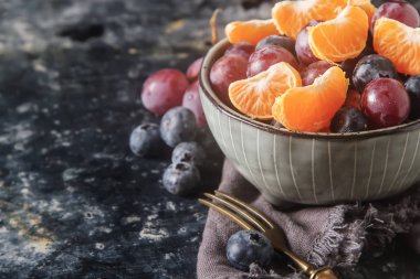 Mandarin, üzüm, yaban mersini meyve salatası ile plaka. Lezzetli 