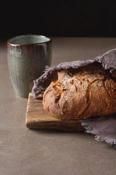 Fresh homemade French black bread. Dark background. — Stock Photo, Image