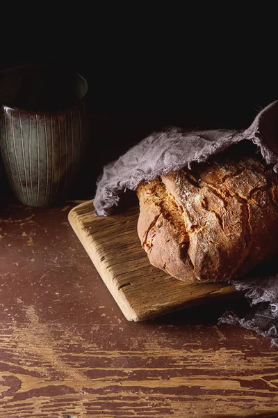 Свежий домашний французский черный хлеб. Темный фон . — стоковое фото