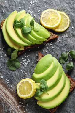 Avokado sandviç taze dilimlenmiş avocad ile yapılan koyu siyah ekmek üzerinde