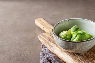 Bir seramik kase taze Brüksel lahanası. Ahşap tahta. Karanlık gra