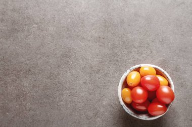 Bir seramik kase taze Olgun Kiraz domates. Koyu gri backgrou