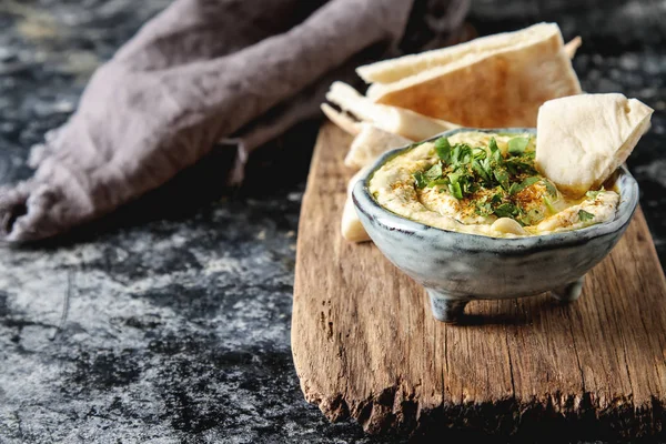 Hummus classique aux herbes, huile d'olive dans un bol en céramique vintage a — Photo