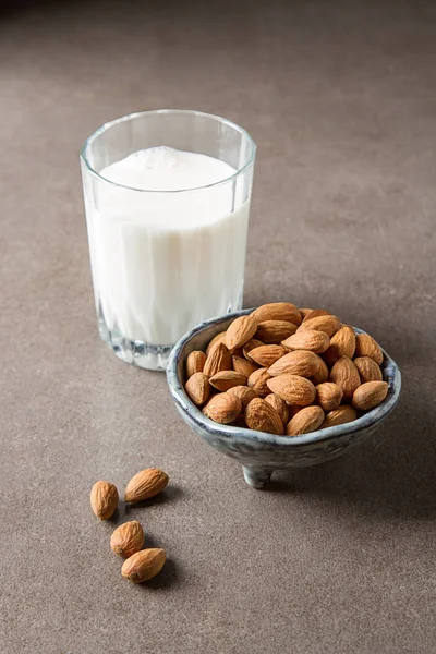นมทางเลือกของนม นมอัลมอนด์ในขวดแก้วและสด — ภาพถ่ายสต็อก