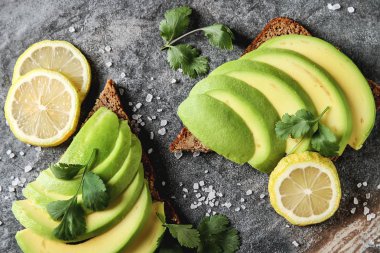 Avokado sandviç taze dilimlenmiş avocad ile yapılan koyu siyah ekmek üzerinde