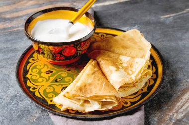 Ekşi krema ile bir tabakta krep yığını. Geleneksel th için