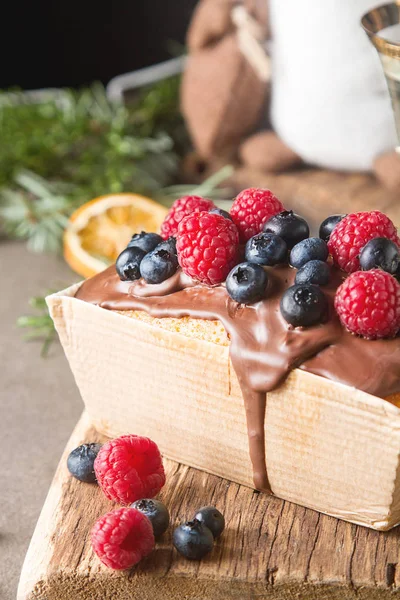 Christmas cake with chocolate frosting, blueberries and raspberr — Stock Photo, Image