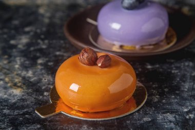 Trendy mousse kek ayna sır ile dekore edilmiştir. Koyu arka plan.