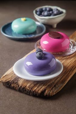 Trendy mousse kek ayna sır ile dekore edilmiştir. Koyu arka plan.