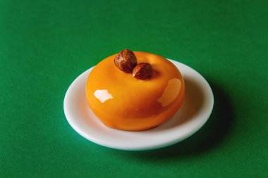 Trendy mousse kek ayna sır ile dekore edilmiştir. Yeşil arka plan