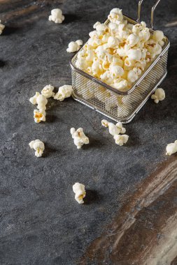 Bir bardak tuzlu patlamış mısır. Koyu arka plan. Seçici odak. Hızlı 