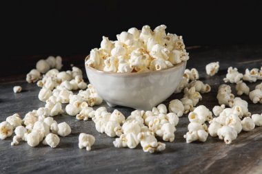 Bir bardak tuzlu patlamış mısır. Koyu arka plan. Seçici odak. Hızlı 