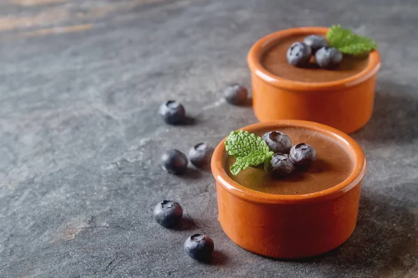 Chocolate mousse with berries in a ceramic bowl. Grey dark backg