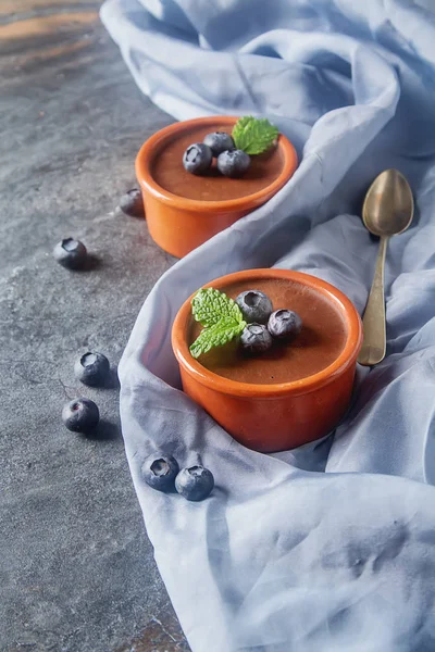 Chocolate mousse with berries in a ceramic bowl. Grey dark backg