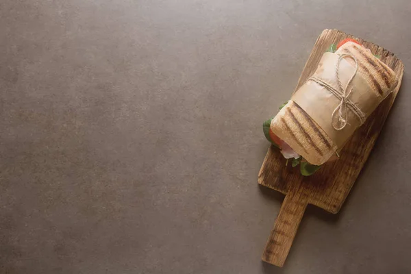 Baguette alla francese con salsiccia, pomodori e lattuga. Backgro scuro — Foto Stock