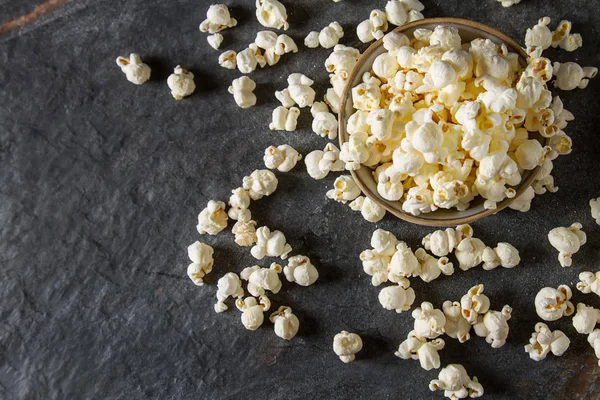 Bir bardak tuzlu patlamış mısır. Koyu arka plan. Seçici odak. Hızlı 