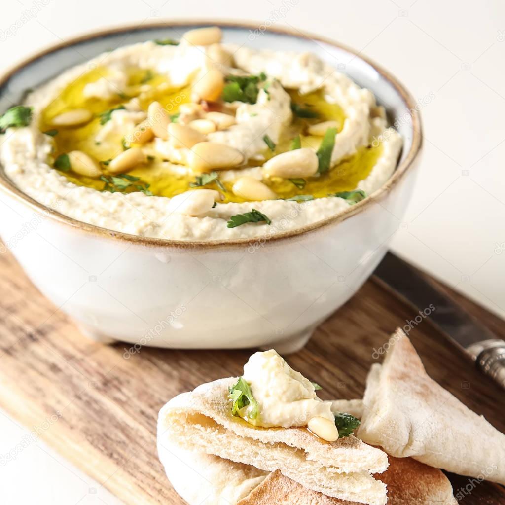 Classic hummus with herbs, olive oil in a vintage ceramic bowl a