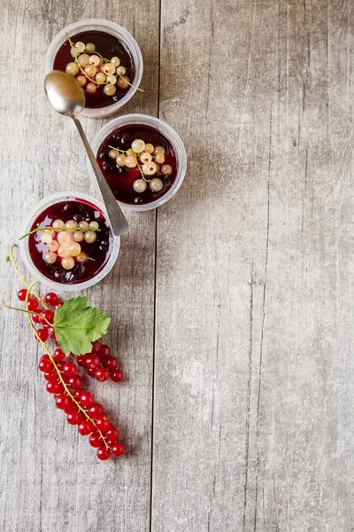 Klaar bessen cheesecake in een plastic pot met witte en rode huidige — Stockfoto