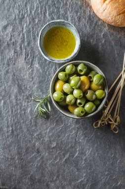 Olivier petrol taze otlar ve ekmek. Gri arka plan. İtalyanca