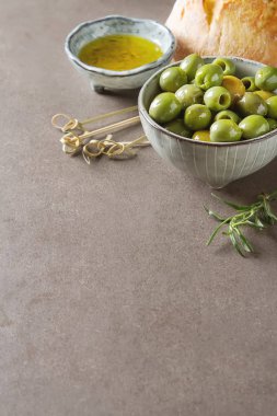 Olivier petrol taze otlar ve ekmek. Gri arka plan. İtalyanca