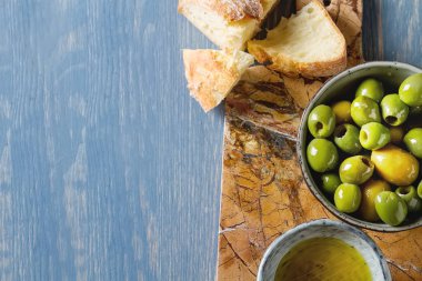 Olivier petrol taze otlar ve ekmek. Mavi arka plan. İtalyanca