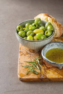 Olivier petrol taze otlar ve ekmek. Gri arka plan. İtalyanca