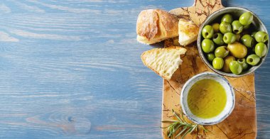 Olivier petrol taze otlar ve ekmek. Mavi arka plan. İtalyanca