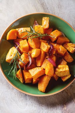 Soğan ve biberiye ile tatlı patates. Koyu arka plan.