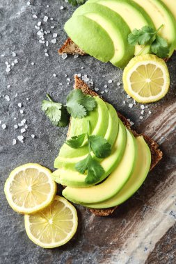 Avokado sandviç taze dilimlenmiş avocad ile yapılan koyu siyah ekmek üzerinde