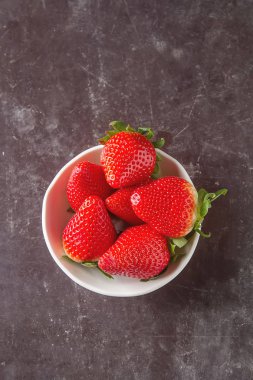 Taze kırmızı çilek ile yeşil yaprakları. Koyu arka plan. Ingredi