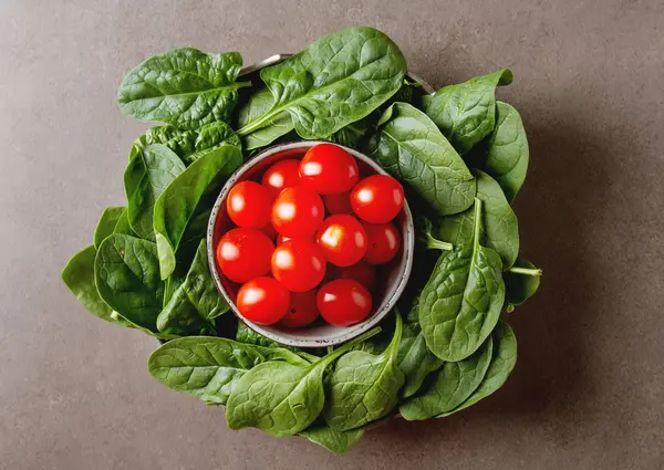 Yıkanmış taze mini ıspanak ve kiraz domates. Koyu arka plan. — Stok fotoğraf