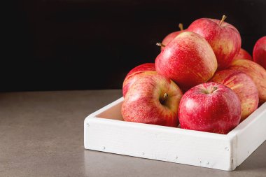 Olgun ve sulu elma bir beyaz ahşap tepsi. Ülke stil. Dar