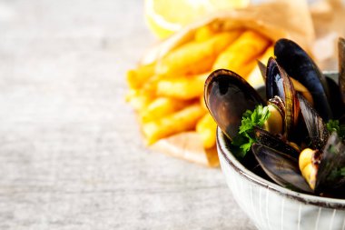 Midye otlar limon ve patates kızartması bir wh üzerinde bir kase ile