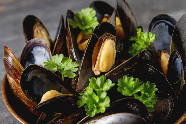 Mussels with herbs in a copper bowl. Seafood. Food at the shore 