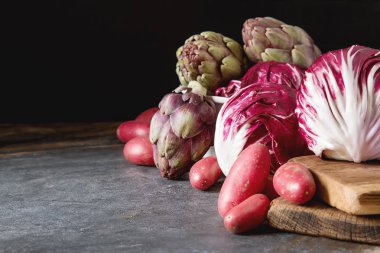 Turpla ile mor patates ve enginar koyu bir adam üzerinde