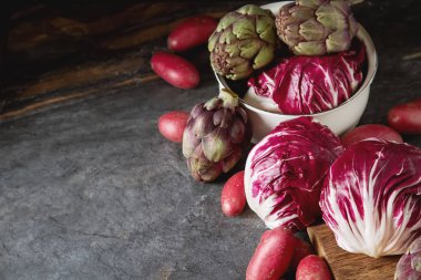 Turpla ile mor patates ve enginar koyu bir adam üzerinde