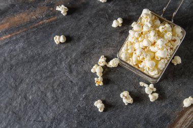 Bir bardak tuzlu patlamış mısır. Koyu arka plan. Seçici odak. Hızlı 