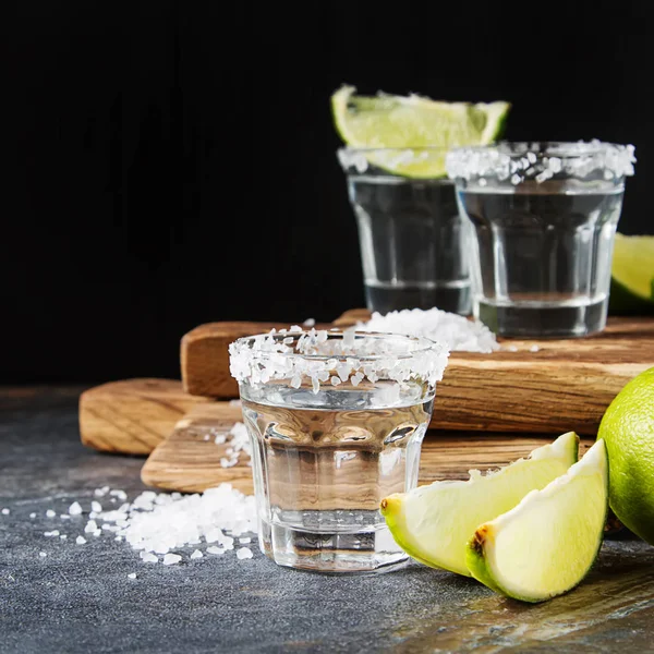 Tequila stříbrná s limetkou a moře sůl. Tmavé pozadí. Selectiv — Stock fotografie