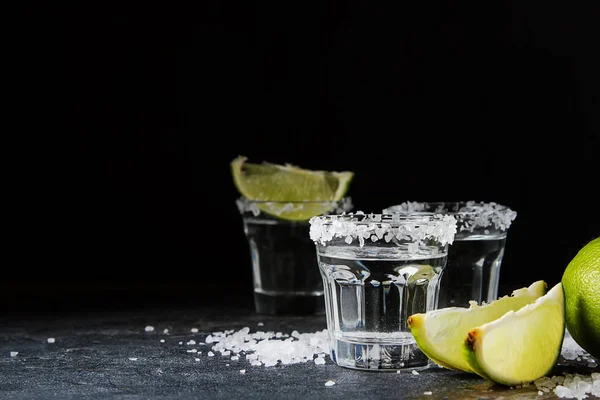 Tequila zilver met limoen en zee zout. Donkere achtergrond. Selectiv — Stockfoto