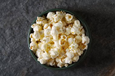 Bir bardak tuzlu patlamış mısır. Koyu arka plan. Seçici odak. Hızlı 