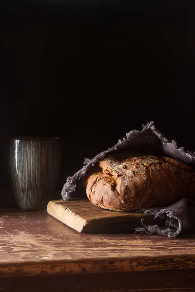 新鮮な自家製フランスの黒いパン。暗い背景. — ストック写真