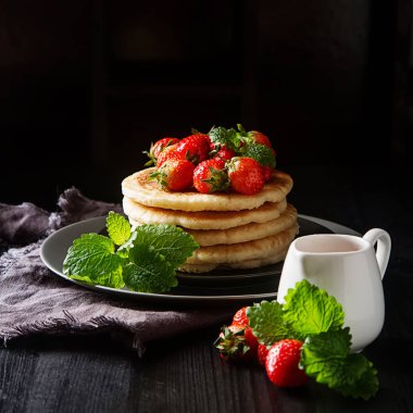 Bir pla üzerinde taze yaban çileği ile ev yapımı krep yığını