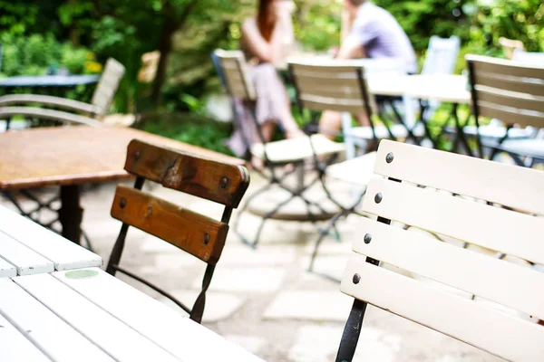 Un café d'été avec des tables en bois blanc dans la rue. De l'herbe ensoleillée — Photo