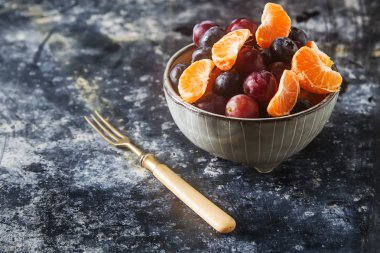 Mandarin, üzüm, yaban mersini meyve salatası ile plaka. Lezzetli 