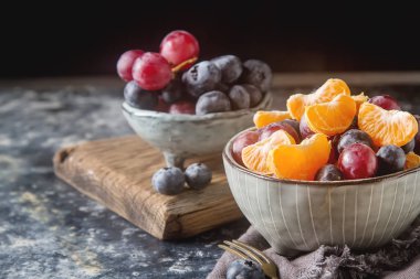 Mandarin, üzüm, yaban mersini meyve salatası ile plaka. Lezzetli 