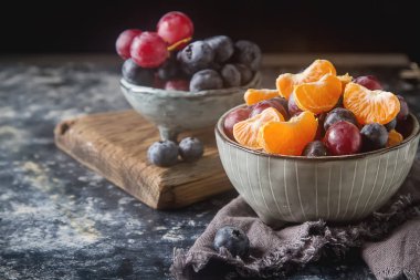 Mandarin, üzüm, yaban mersini meyve salatası ile plaka. Lezzetli 