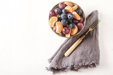 Mandarin, üzüm, yaban mersini meyve salatası ile plaka. Lezzetli 