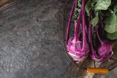 Yeşil yaprakları ile olgun mor şalgam. Gri taş arka plan.