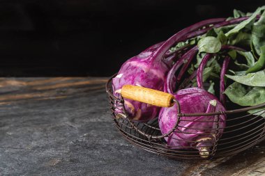 Yeşil yaprakları ile olgun mor şalgam. Gri taş arka plan.