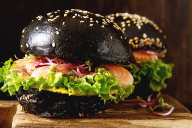 Somon Balık, marul, hardal ile siyah burger. Koyu arka plan